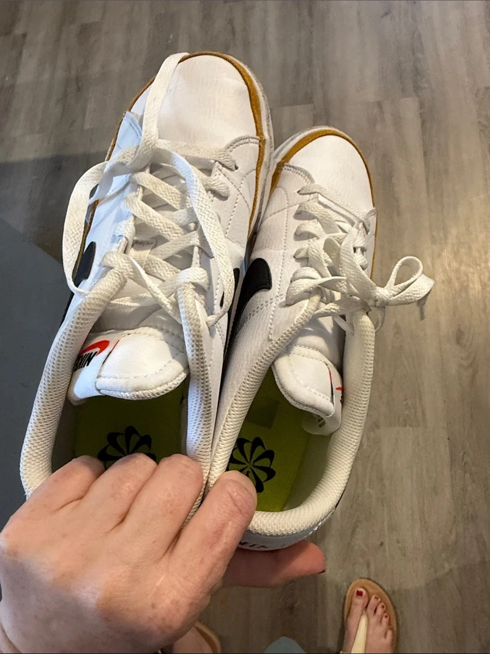 Nike Men’s White Low-Top Sneaker with Black Swoosh and Gold Accent
